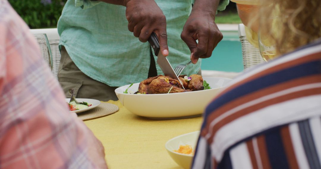 Close-up of person carving roasted chicken for poolside meal - Free Images, Stock Photos and Pictures on Pikwizard.com