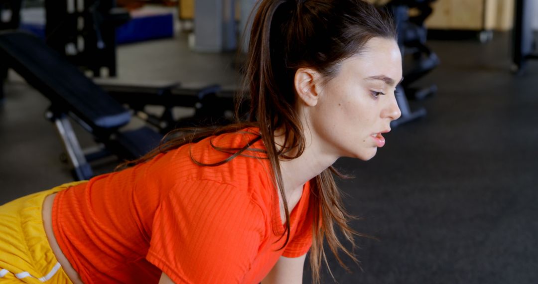 Determined Woman Exercising with Barbell in Gym