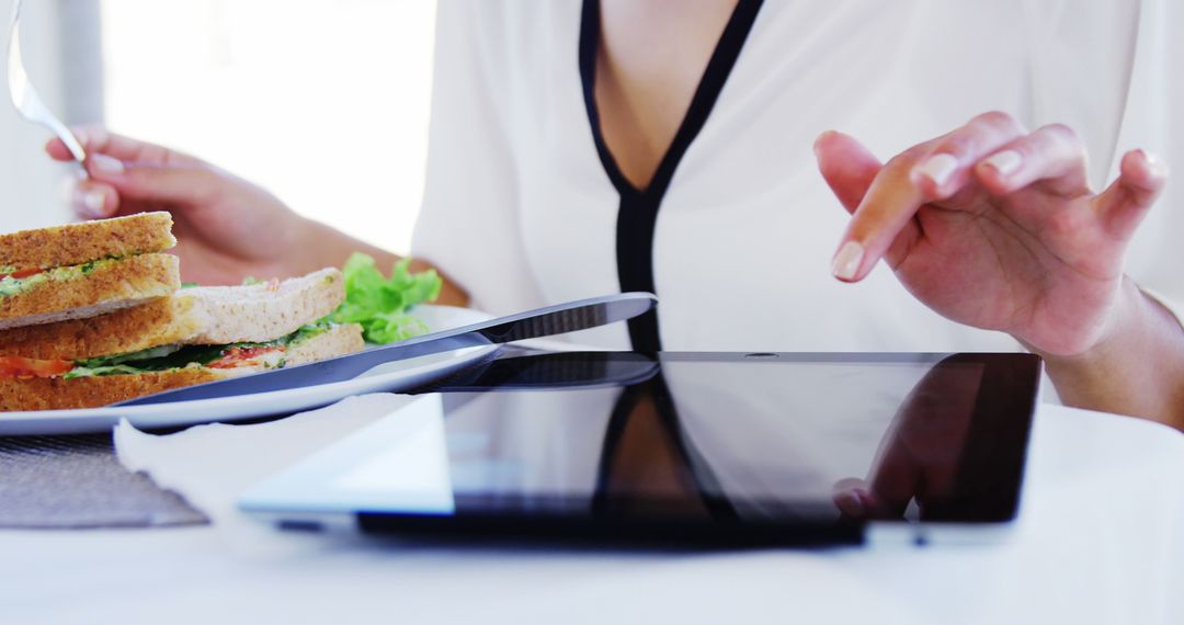 Woman Eating Healthy Sandwich While Using Tablet - Free Images, Stock Photos and Pictures on Pikwizard.com