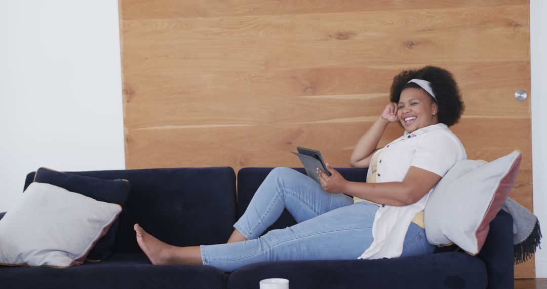 Happy Woman Relaxing with Tablet on Cozy Couch at Home