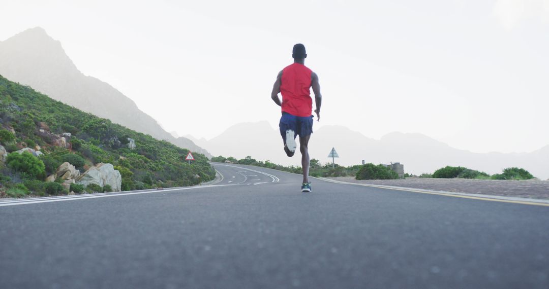 Athlete Running on Scenic Road near Mountains - Free Images, Stock Photos and Pictures on Pikwizard.com