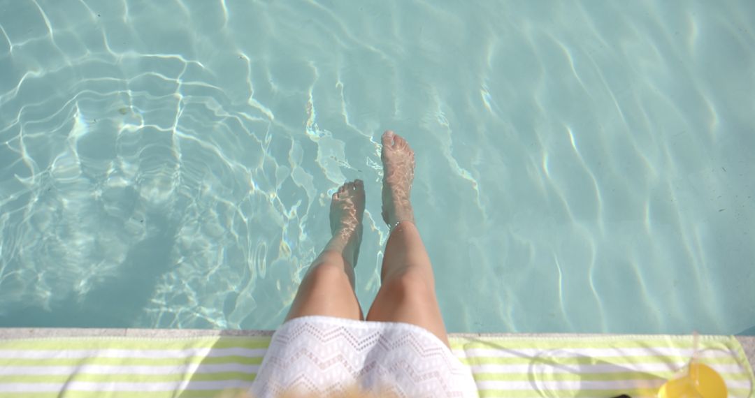 Relaxing by Poolside with Feet Dipping in Water
