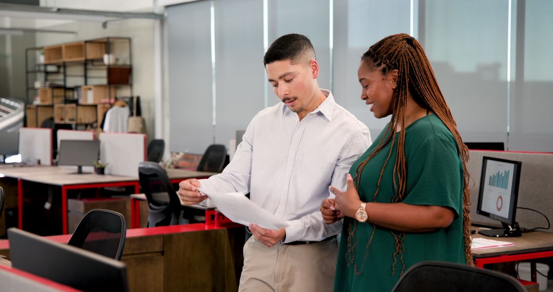 Colleagues Collaborating on Project Details in Modern Office