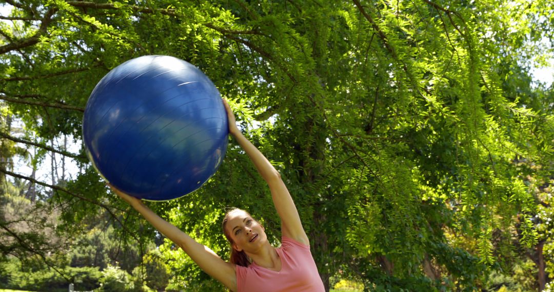 Woman Exercising with Fitness Ball Outdoors in Green Park - Free Images, Stock Photos and Pictures on Pikwizard.com