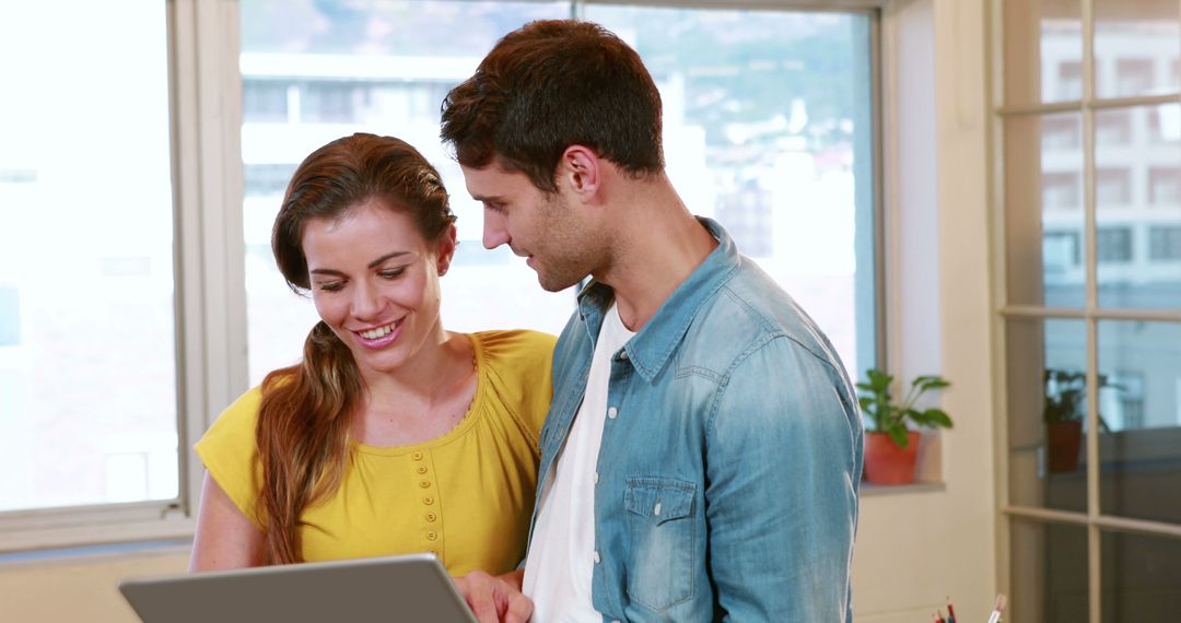 Diverse Colleagues Collaborating on Laptop in Office Setting