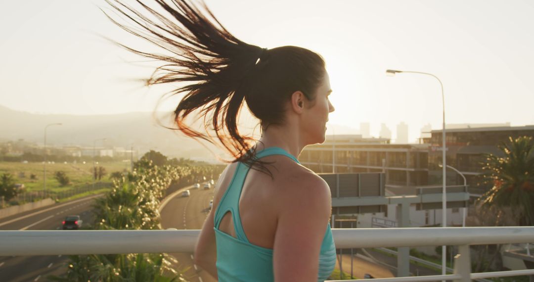 Woman Running on Bridge with City Background at Sunset - Free Images, Stock Photos and Pictures on Pikwizard.com