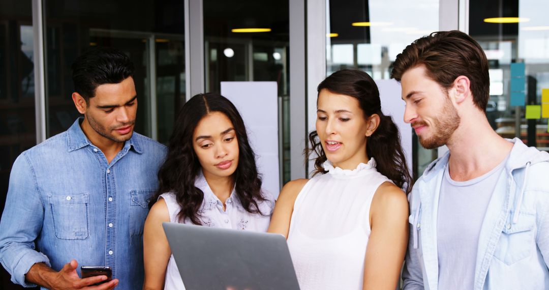 Team Collaboration on Laptop in Modern Office Environment