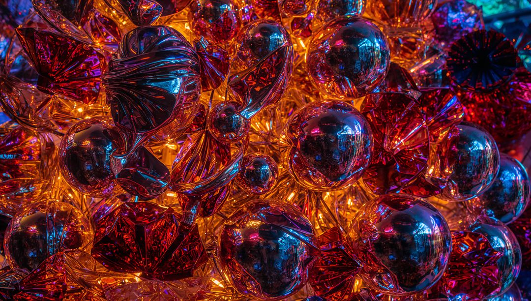 Vibrant metallic holiday ornaments glowing with twisted foil reflections and warm bokeh