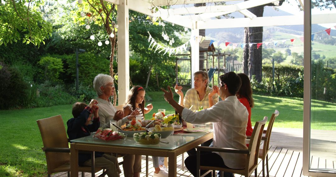 Multi-generational family enjoying outdoor meal in garden - Free Images, Stock Photos and Pictures on Pikwizard.com