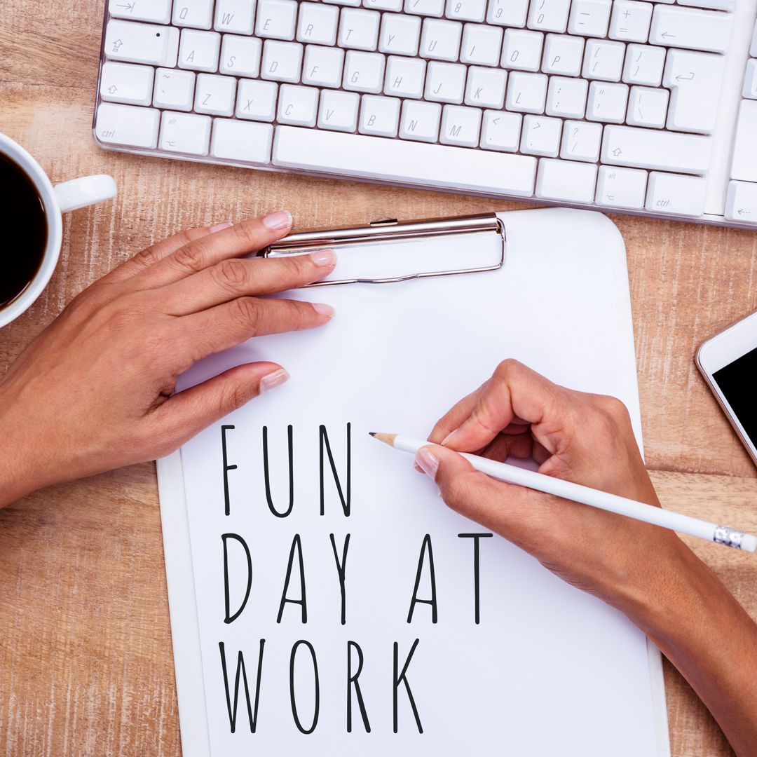 Hands Writing FUN DAY AT WORK on Paper