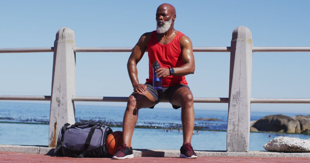 Senior Man Sitting Near Ocean After Outdoor Workout - Free Images, Stock Photos and Pictures on Pikwizard.com