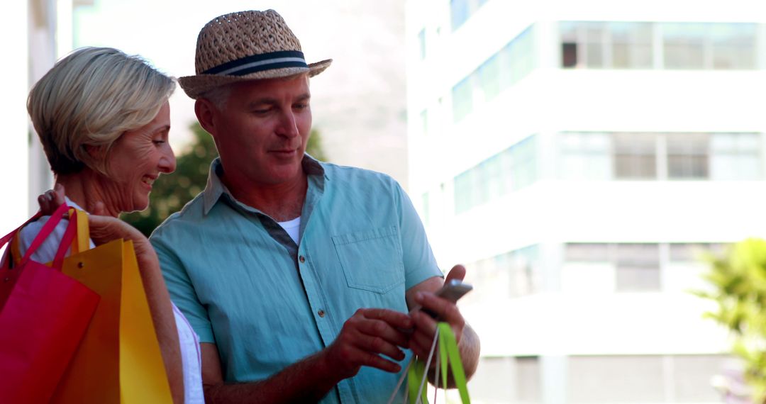 Senior Couple Shopping Outdoors and Using Smartphone on a Sunny Day