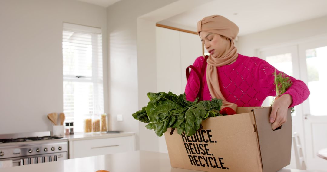 Ethnic Woman Unpacking Fresh Produce from Recycled Box in Kitchen - Free Images, Stock Photos and Pictures on Pikwizard.com