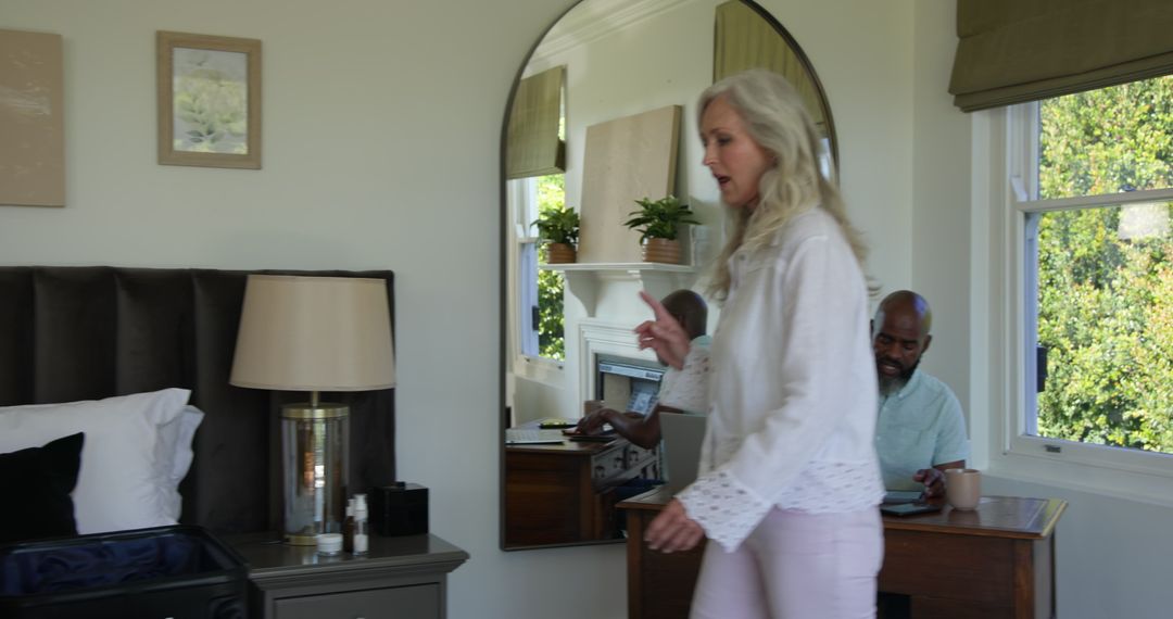 Woman Packing Suitcase While Man Works Remotely on Laptop