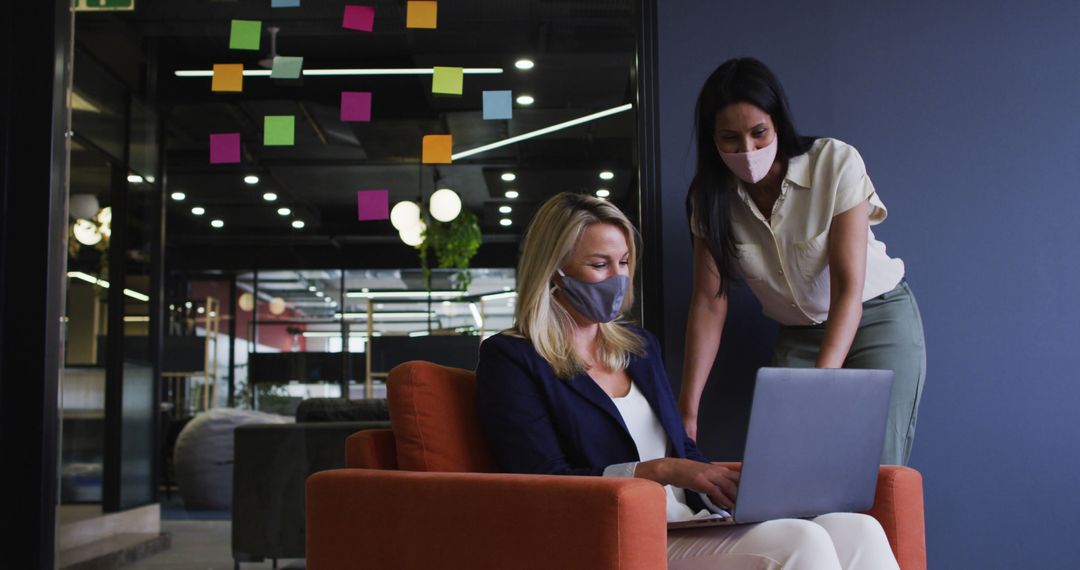 Businesswomen Collaborating on Laptop in Modern Office with Sticky Notes - Free Images, Stock Photos and Pictures on Pikwizard.com