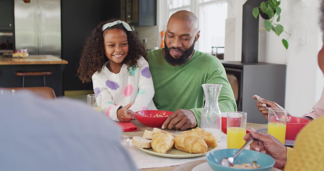 Happy African American Daughter Laughing and Feeding Father at Family Breakfast Table - Free Images, Stock Photos and Pictures on Pikwizard.com