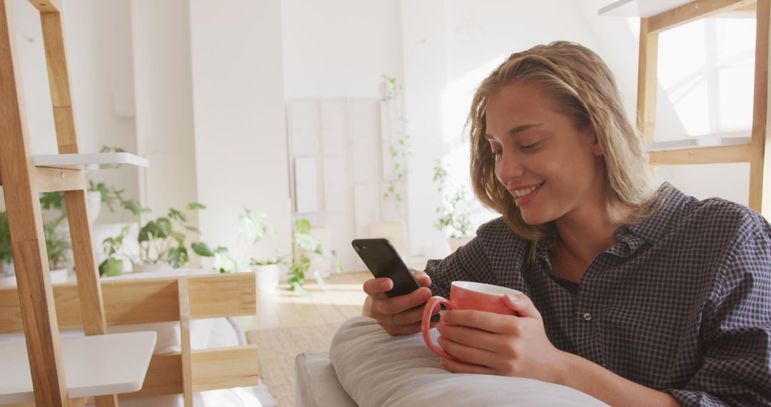 Woman Relaxing at Home with Smartphone and Tea