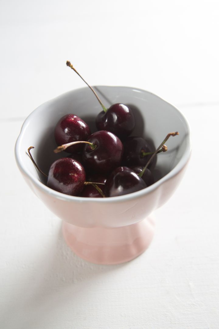 Fresh Cherries in Pink Bowl on White Table - Free Images, Stock Photos and Pictures on Pikwizard.com