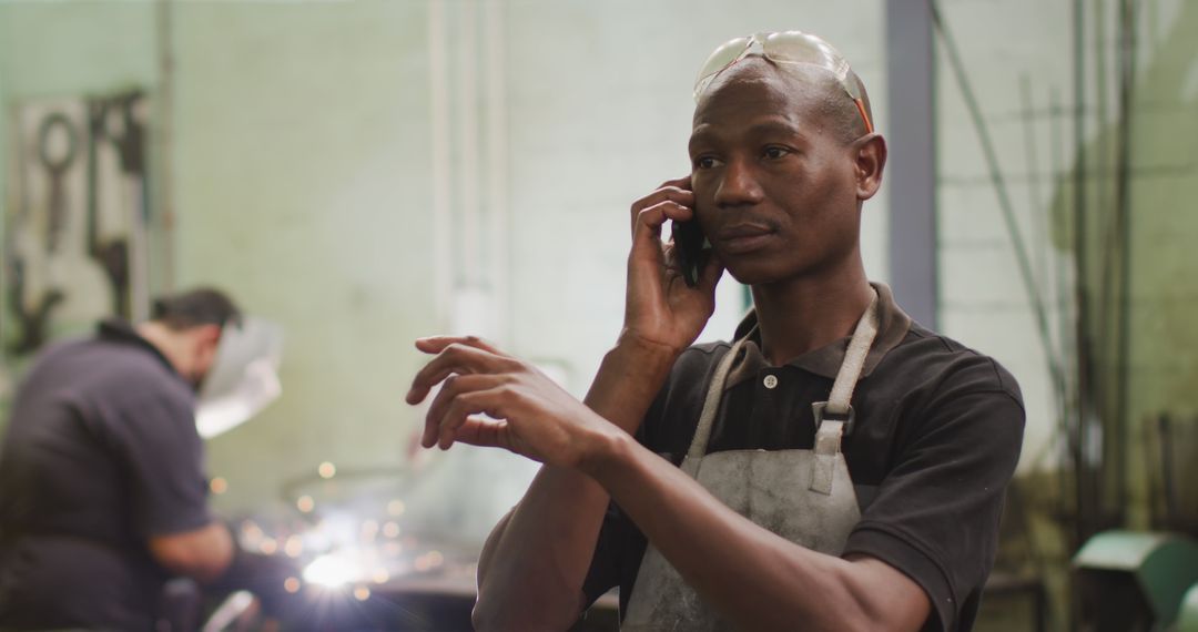 Industrial Worker Talking on Smartphone in Factory - Free Images, Stock Photos and Pictures on Pikwizard.com