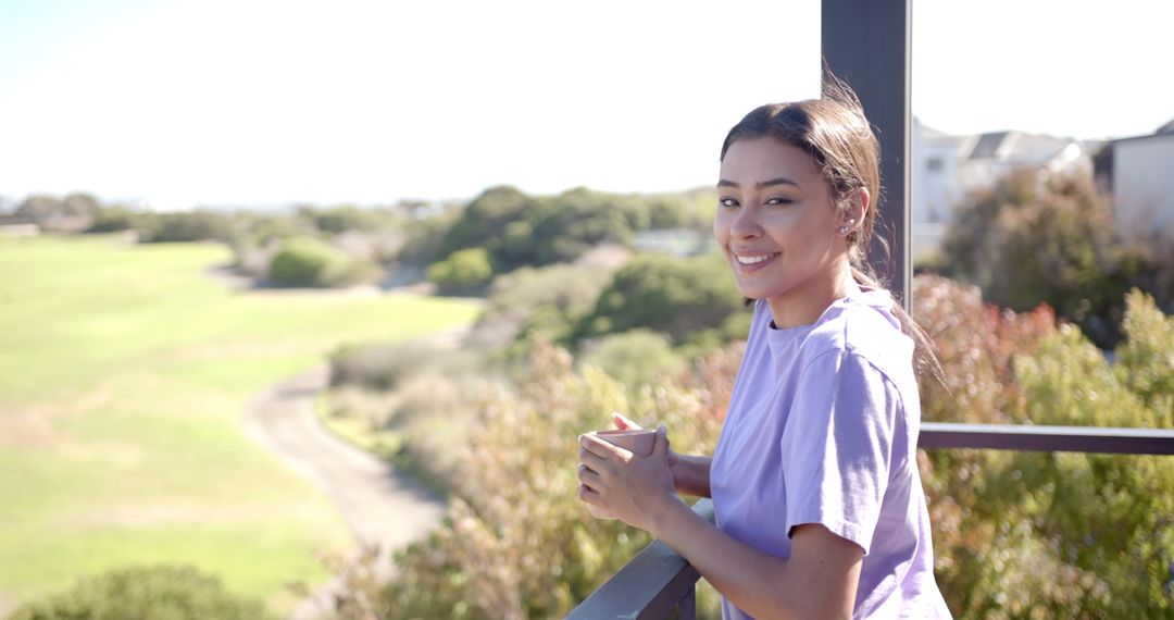 Smiling Woman Enjoys Scenic View from Balcony with Coffee