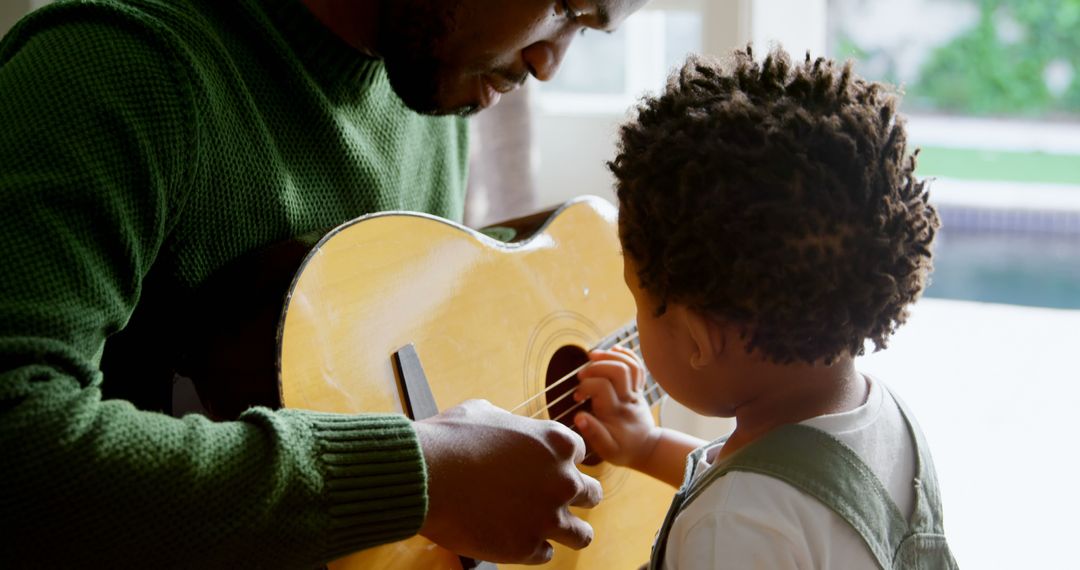 Father Teaching Young Son to Play Guitar at Home - Free Images, Stock Photos and Pictures on Pikwizard.com