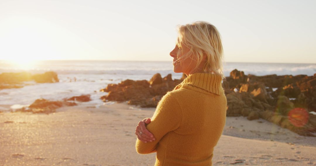 Woman Enjoying Sunset at Beach in Cozy Sweater - Free Images, Stock Photos and Pictures on Pikwizard.com