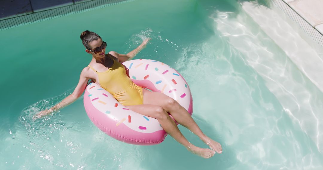 Woman Relaxing on Donut Float in Sparkling Pool