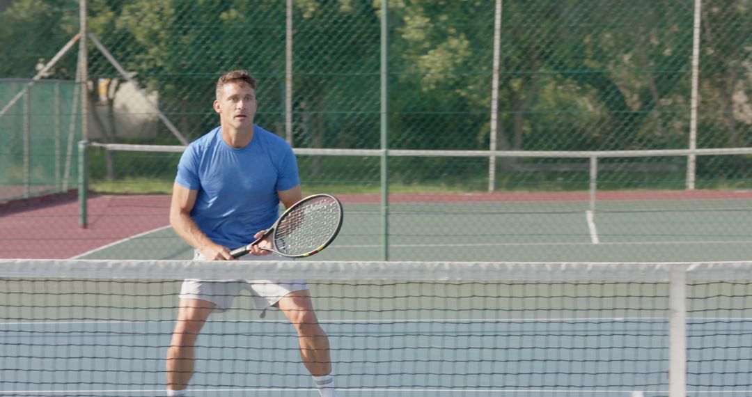 Male Tennis Player Wearing Blue T-shirt on Outdoor Court Ready to Return Volley - Free Images, Stock Photos and Pictures on Pikwizard.com