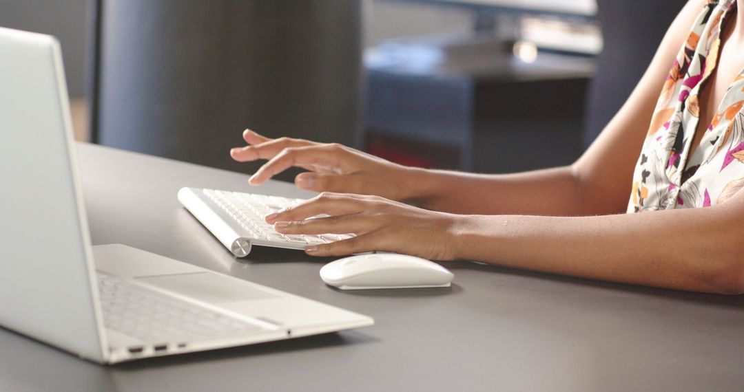 Hands Typing on Wireless Keyboard in Modern Workspace