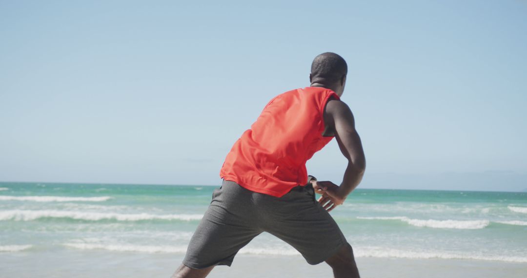 Man stretching on beach with ocean background - Free Images, Stock Photos and Pictures on Pikwizard.com