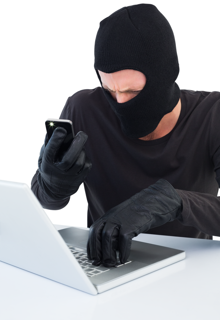 Cybercriminal in Mask on Laptop Using Smartphone Transparent Background - Download Free Stock Images Pikwizard.com