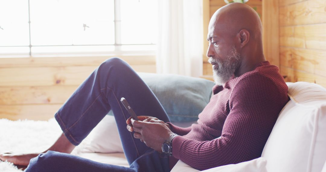 Mature man relaxing on couch using digital tablet - Free Images, Stock Photos and Pictures on Pikwizard.com