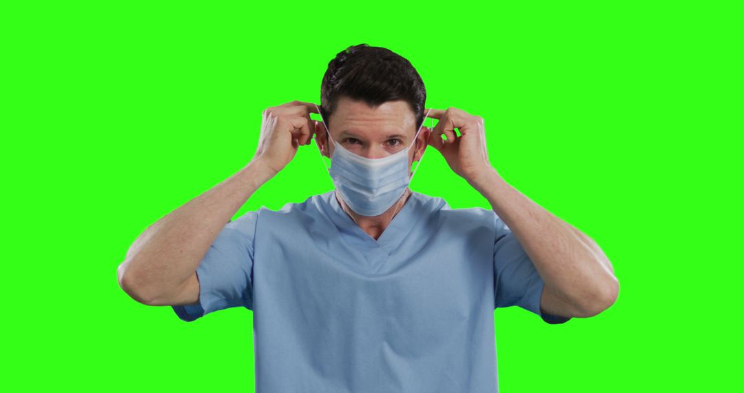 Doctor Putting on Face Mask Isolated on Green Background - Free Images, Stock Photos and Pictures on Pikwizard.com