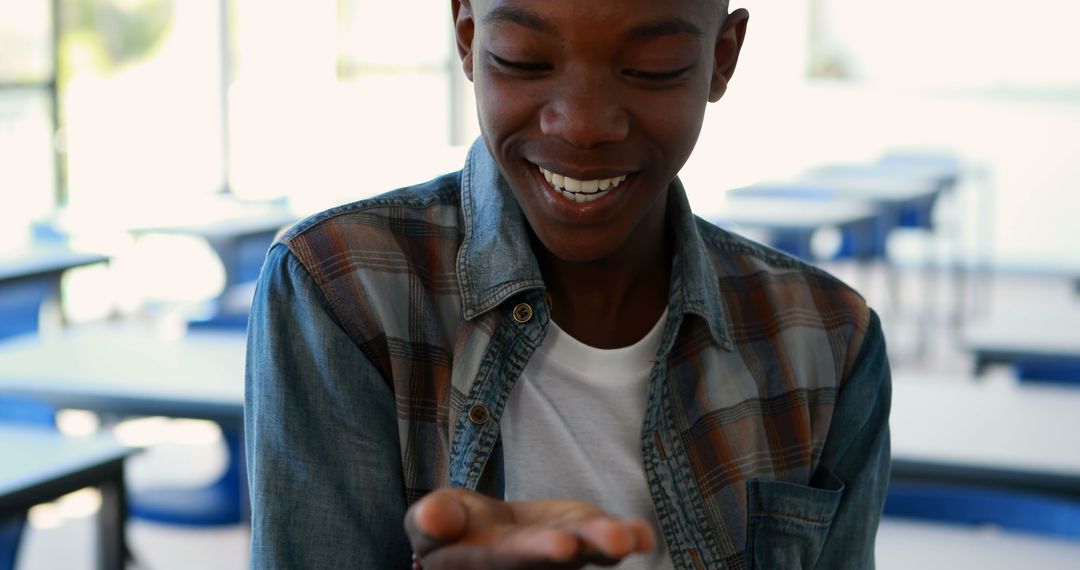 Smiling Schoolboy Examining Hand During Class
