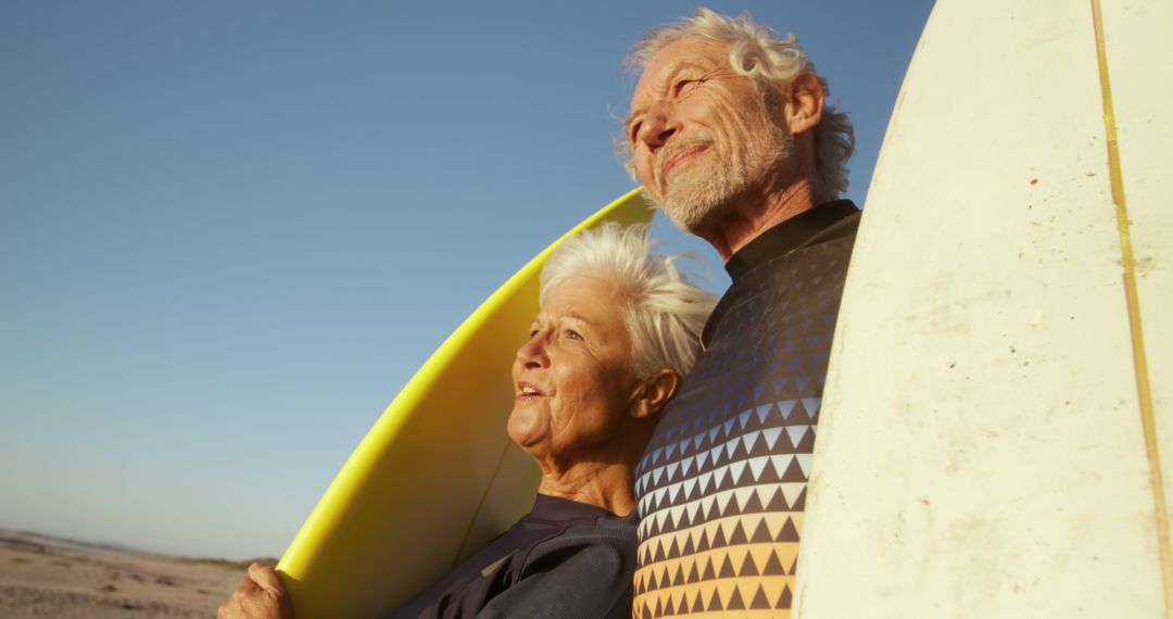 Senior Couple Bonding with Surfboards at Beach during Sunrise - Free Images, Stock Photos and Pictures on Pikwizard.com