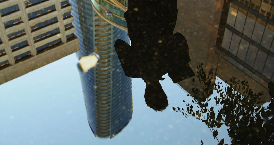 Abstract Reflection of Businessman in Urban Puddle with Skyscraper - Free Images, Stock Photos and Pictures on Pikwizard.com