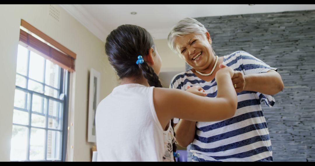 Grandmother and Granddaughter Dancing Together Happily at Home - Free Images, Stock Photos and Pictures on Pikwizard.com