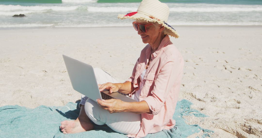 Senior Woman Enjoying Tech on Sandy Beach - Free Images, Stock Photos and Pictures on Pikwizard.com