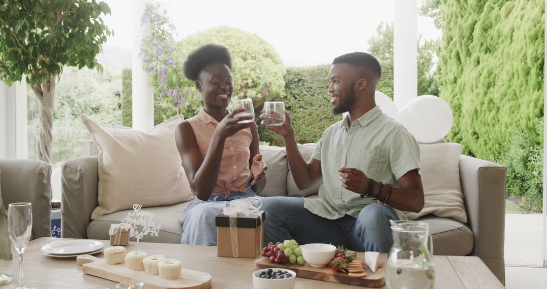 Joyful Couple Enjoying Outdoor Picnic with Drinks and Snacks