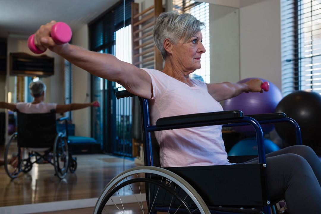 Senior woman in wheelchair performing exercise with dumbbell  - Free Images, Stock Photos and Pictures on Pikwizard.com
