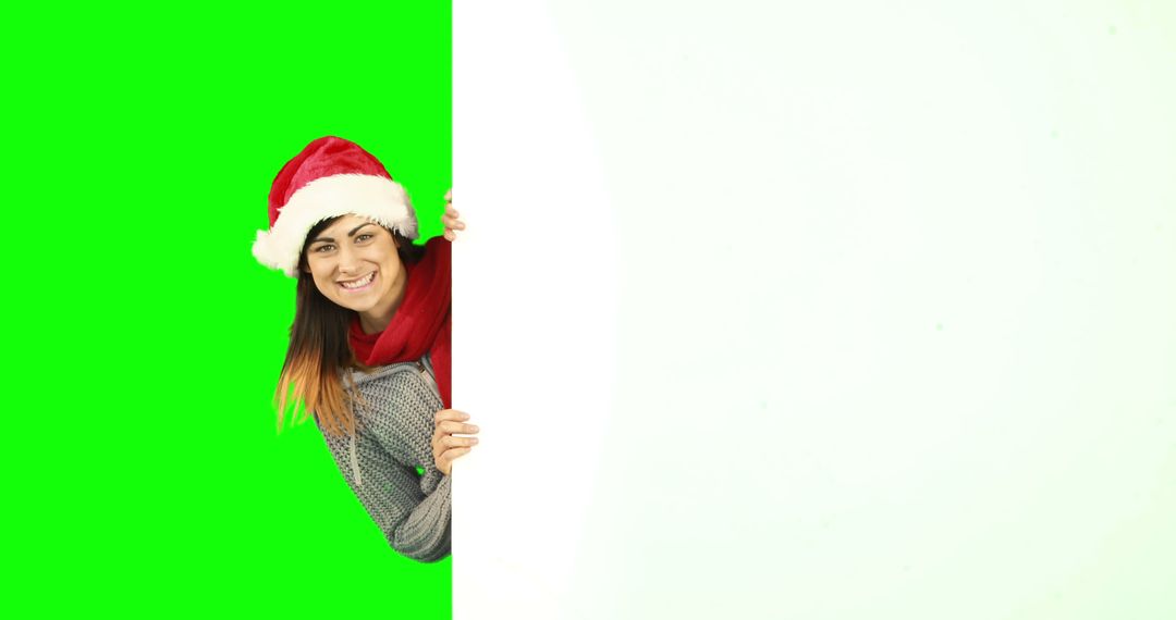 Woman in Santa Hat and Scarf Peeking Around Blank Sign with Green Background - Free Images, Stock Photos and Pictures on Pikwizard.com