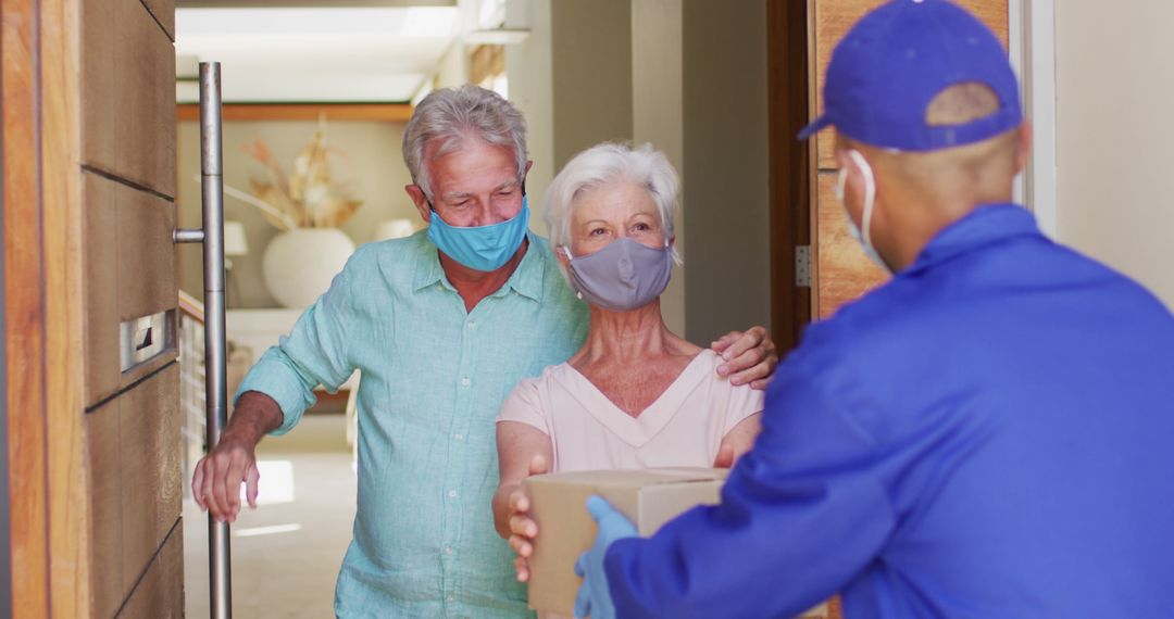 Senior Couple Receiving Package from Delivery Man During Pandemic