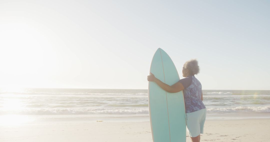 Woman Holding Surfboard at Beautiful Sunset Beach - Free Images, Stock Photos and Pictures on Pikwizard.com