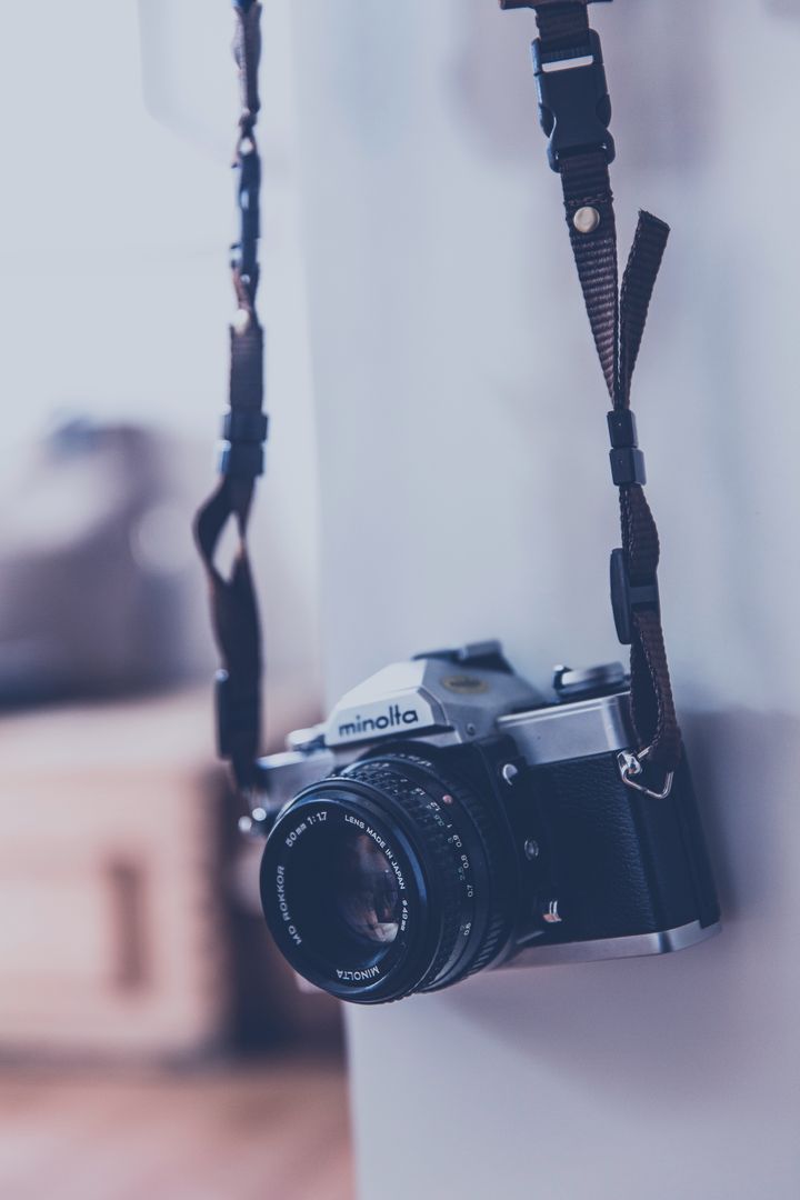 Vintage Camera Hanging by Strap with Soft Background - Free Images, Stock Photos and Pictures on Pikwizard.com