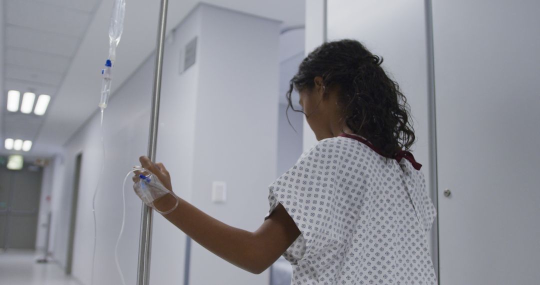 Biracial girl walking with drip bag in hospital room - Free Images, Stock Photos and Pictures on Pikwizard.com