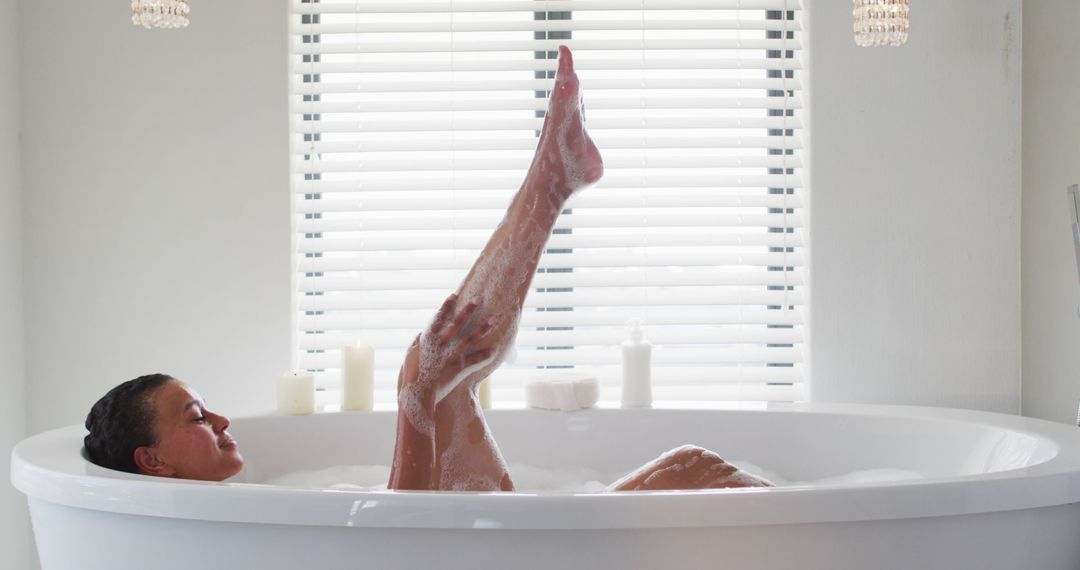 Relaxed Woman Enjoying Bath in Minimalist White Bathroom - Free Images, Stock Photos and Pictures on Pikwizard.com