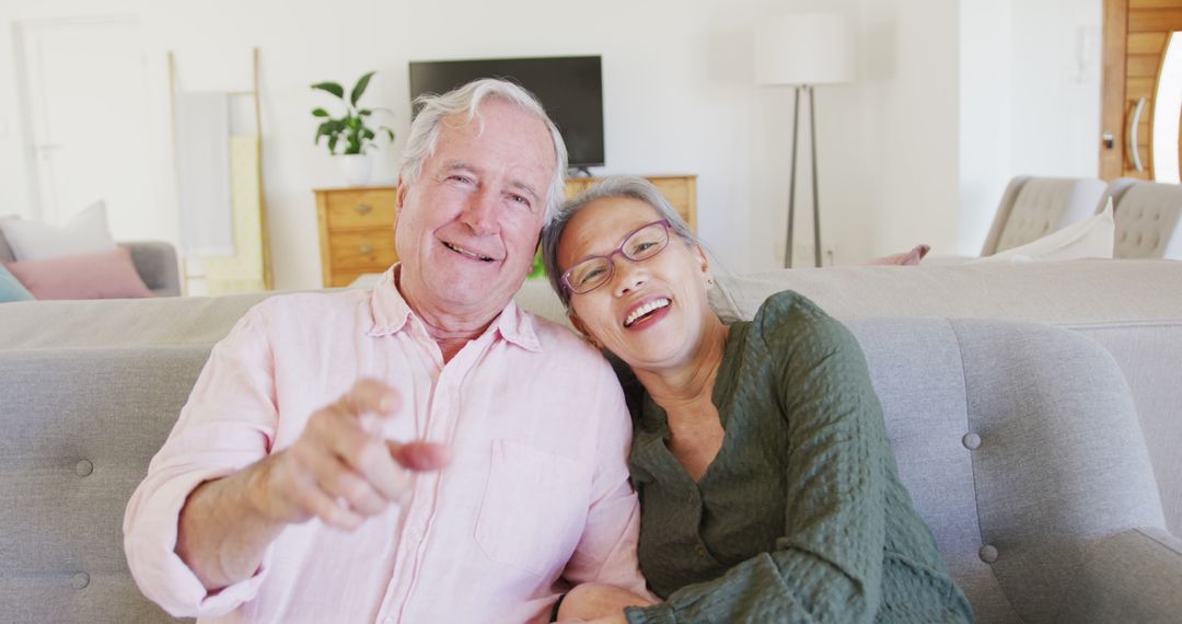 Happy Senior Couple Relaxing on Sofa Smiling and Laughing - Free Images, Stock Photos and Pictures on Pikwizard.com