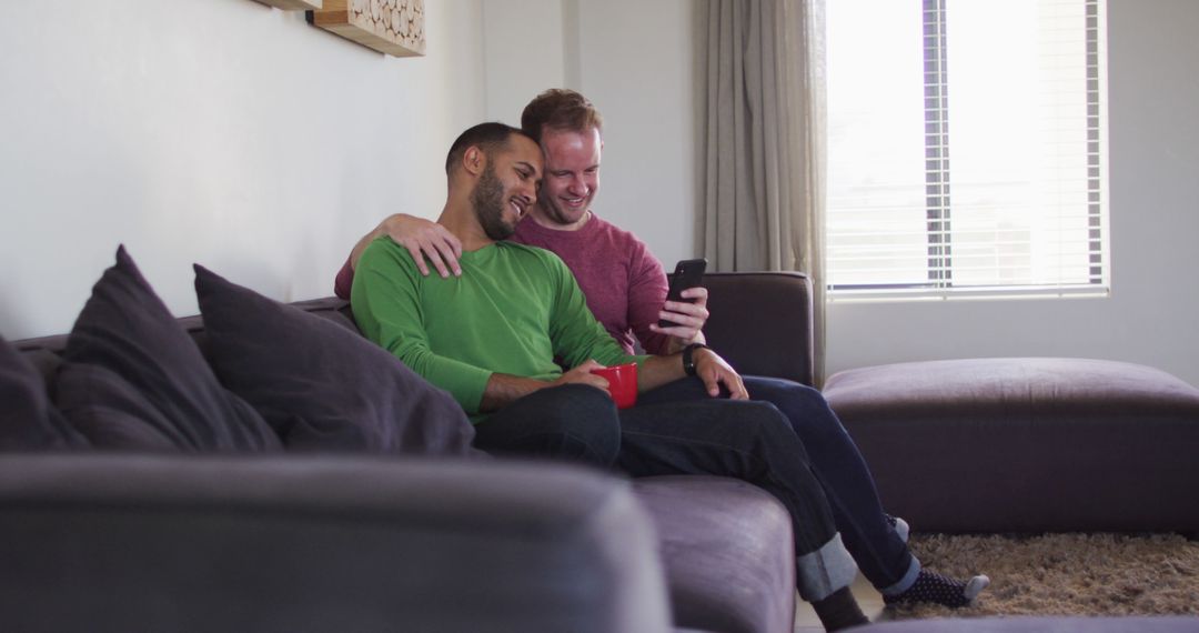 Happy Couple Sharing Relaxing Moment on Sofa with Smartphone