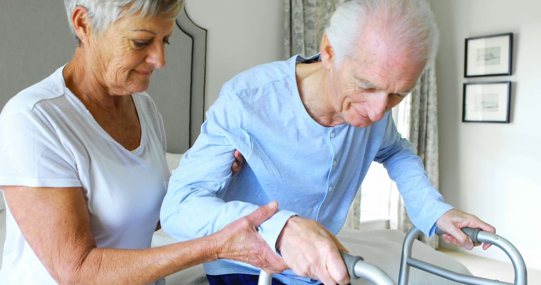 Senior man receiving help with walker from caregiver in bedroom - Free Images, Stock Photos and Pictures on Pikwizard.com