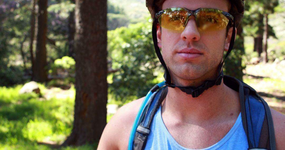 Confident Cyclist Wearing Helmet and Sunglasses in Sunlit Forest - Free Images, Stock Photos and Pictures on Pikwizard.com